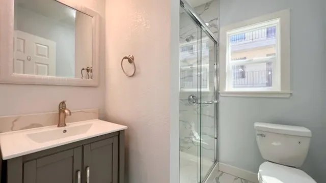 a bathroom with a toilet sink and mirror