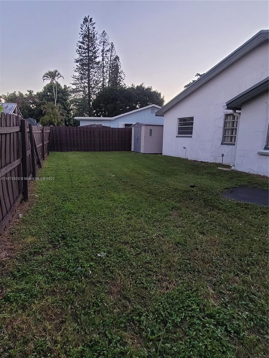 22780 Family Circle Boca Raton, FL 33428 - Photo 4 of 19 a view of a backyard with large trees and wooden fence