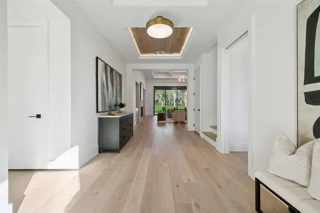 a view of a hallway with wooden floor and furniture