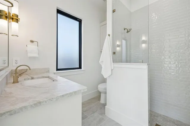 a bathroom with a sink a toilet and a mirror