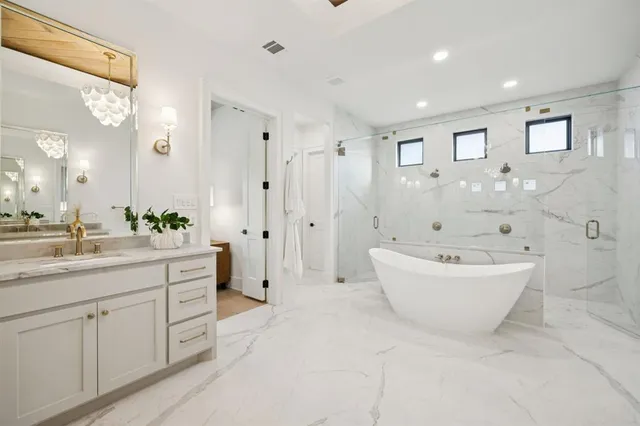 a spacious bathroom with a bathtub shower sink double and mirror