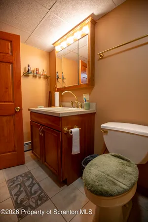 a bathroom with a toilet mirror and vanity