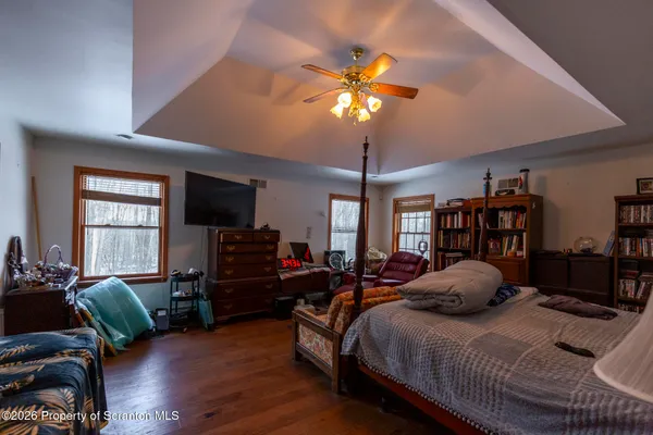 a bedroom with a bed chandelier and a window