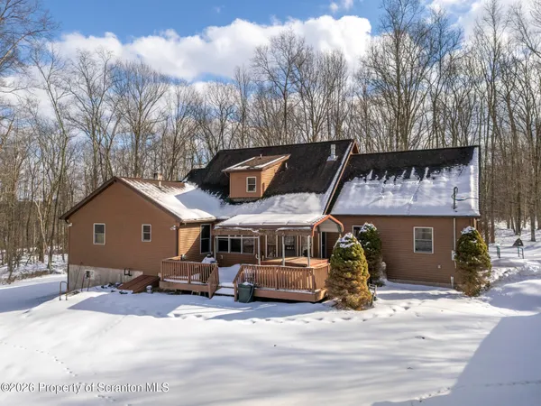 a front view of a house with a yard covered in snow