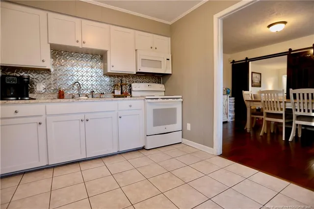 a kitchen with white cabinets and sink