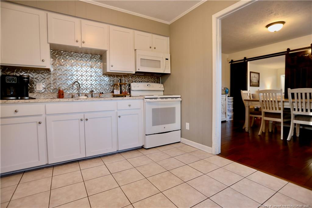 948 Pinebluff Lake Road Aberdeen, NC 28315 - Photo 17 of 32 a kitchen with white cabinets and sink