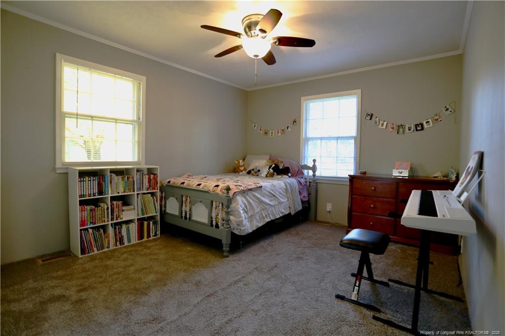 948 Pinebluff Lake Road Aberdeen, NC 28315 - Photo 23 of 32 a bedroom with a bed and a chandelier