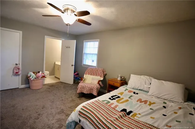 a bedroom with two beds and ceiling fan