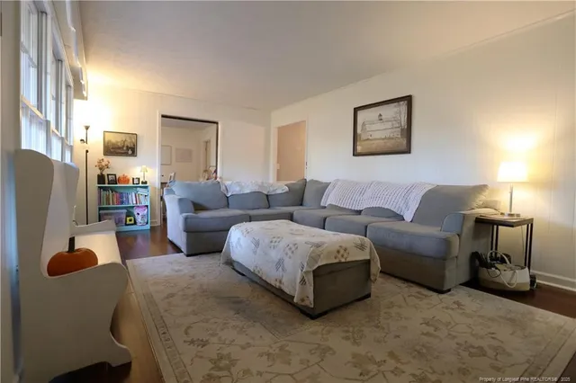 a living room with furniture a lamp and a large window