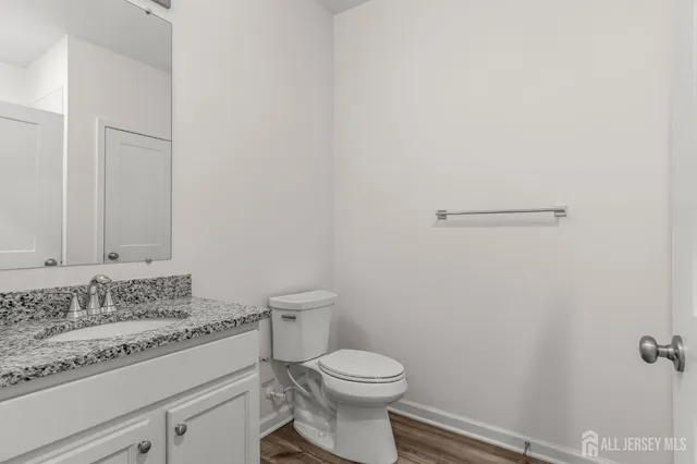 a bathroom with a granite countertop toilet and a sink