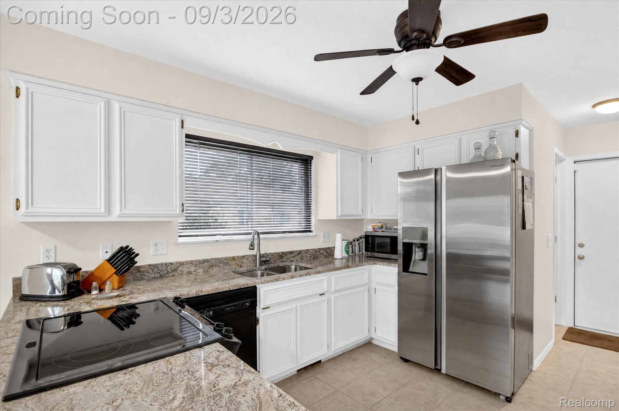 27260 Campbell Road Warren, MI 48093 - Photo 15 of 60 White cabinetry with black hardware, stone-finish countertops, stainless steel side-by-side refrigerator, recessed lighting, and tile flooring