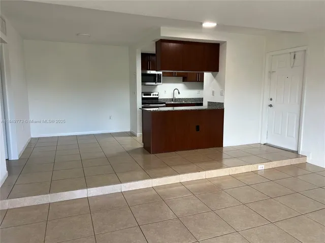 a kitchen with stainless steel appliances granite countertop a sink and a stove