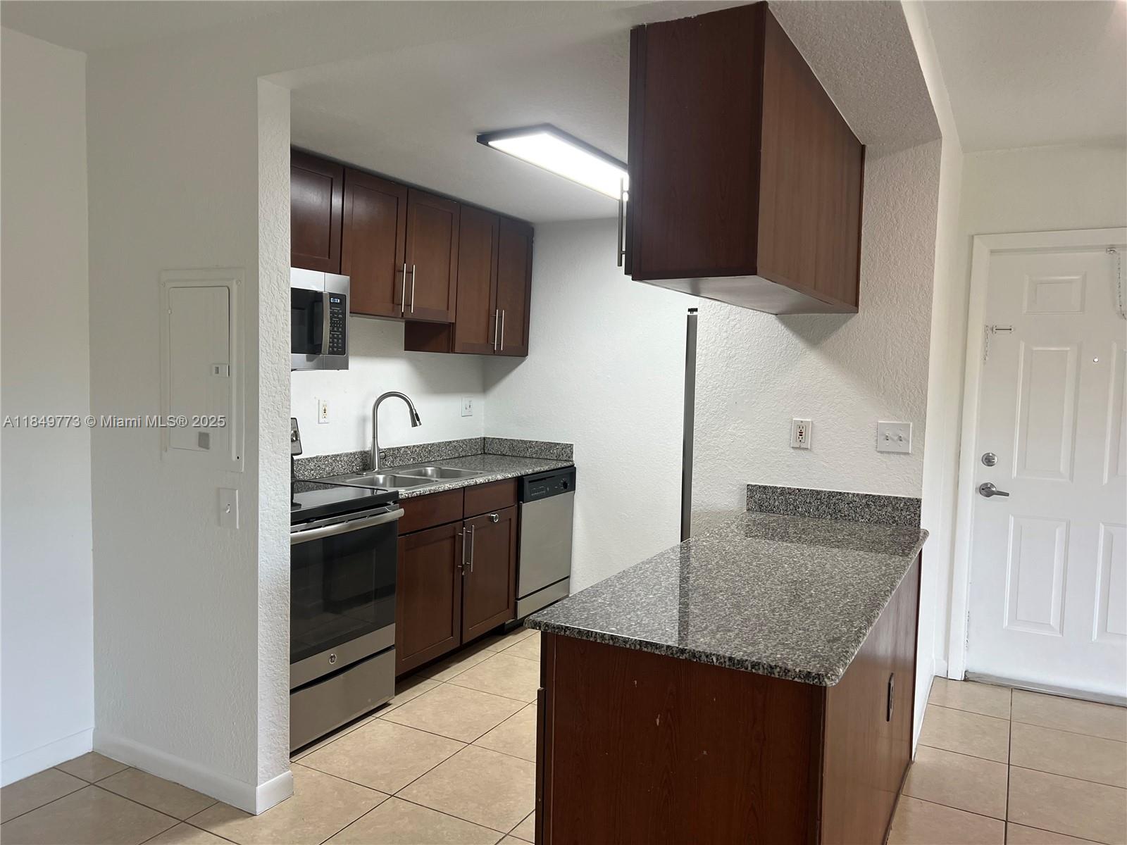 8950 Southwest 69th Court, Unit 312 Pinecrest, FL 33156 - Photo 7 of 13 a kitchen with stainless steel appliances granite countertop a sink and a stove