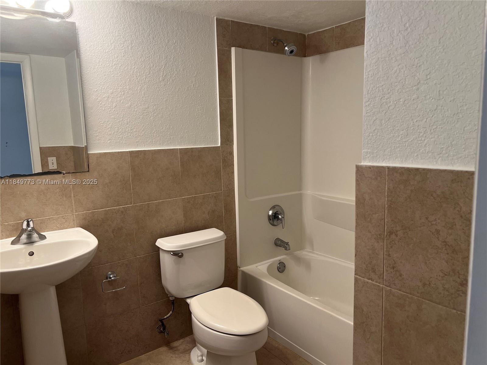 8950 Southwest 69th Court, Unit 312 Pinecrest, FL 33156 - Photo 8 of 13 a bathroom with a sink a toilet and shower