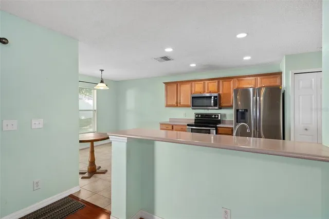 a kitchen with stainless steel appliances a refrigerator and a stove top oven