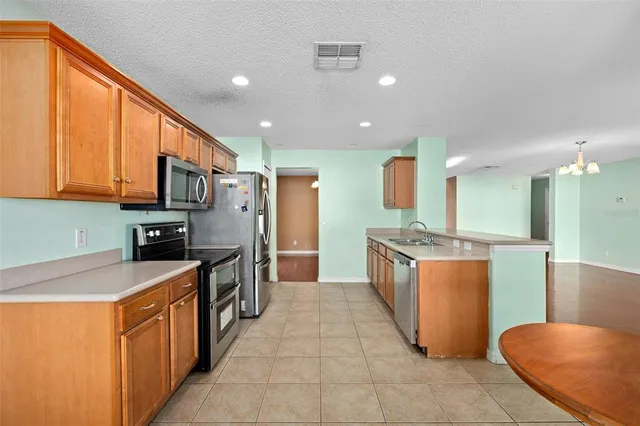 a large kitchen with stainless steel appliances lots of counter top space