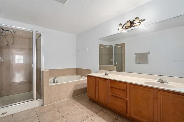 a spacious bathroom with a tub sink and mirror