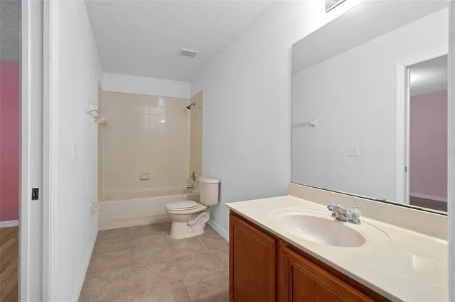 a bathroom with a granite countertop sink a toilet and a large mirror