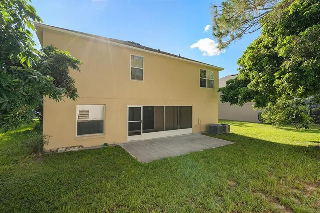 a view of an house with backyard and a tree