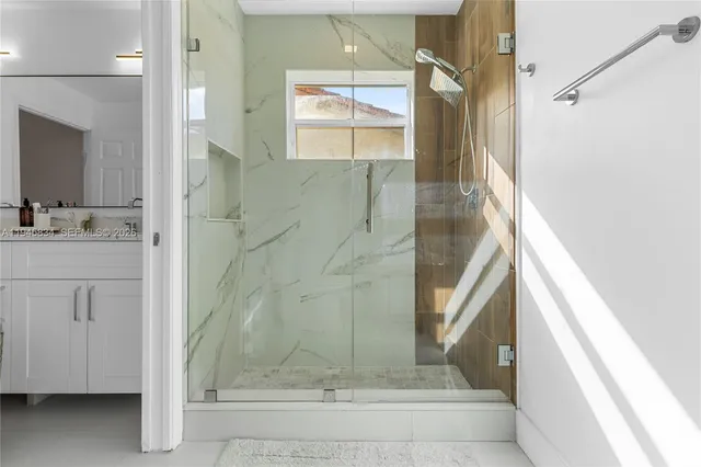 a bathroom with a granite countertop shower sink and mirror