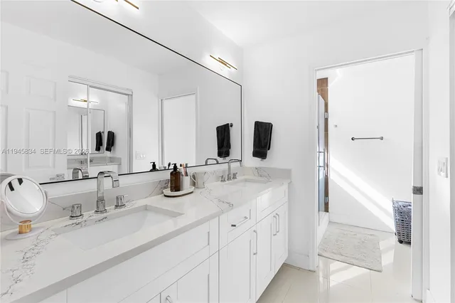 a bathroom with double sink and a mirror