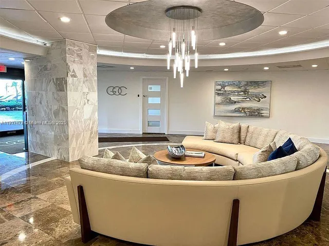 a living room with furniture and a chandelier