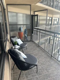 a balcony with table and chairs