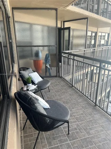 a balcony with table and chairs