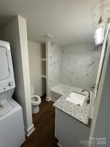 a bathroom with a granite countertop sink a toilet and a shower