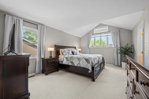a bedroom with a bed flat screen tv and a window