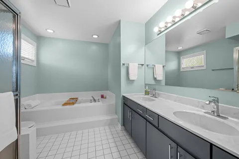 a bathroom with a tub sink and mirror