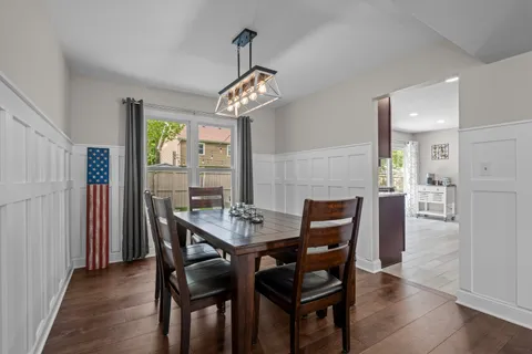 a view of a dining room with furniture a chandelier and wooden floor