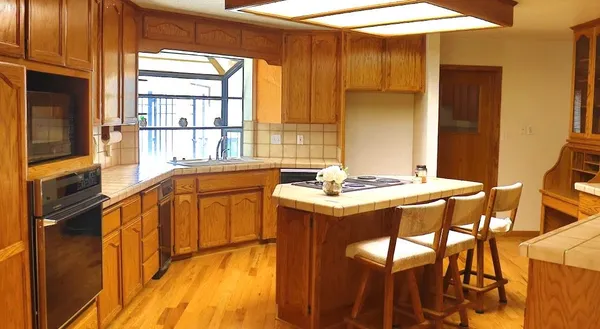 a view of a kitchen that has a sink and a large window