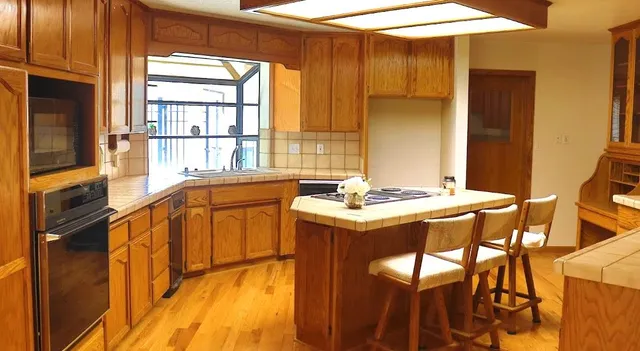 a view of a kitchen that has a sink and a large window