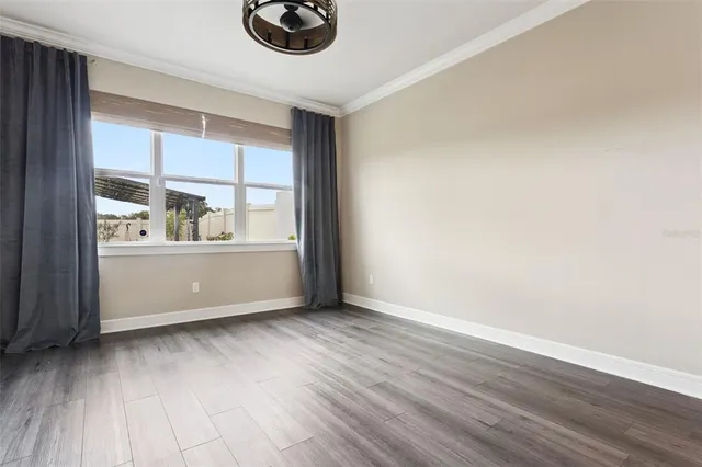 a view of an empty room with wooden floor