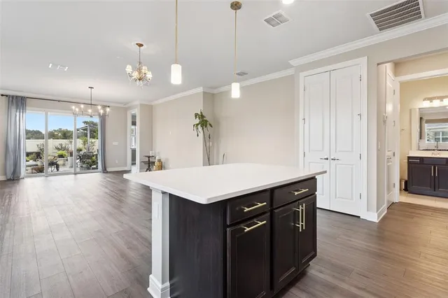 a large kitchen with stainless steel appliances a large counter top a sink and cabinets