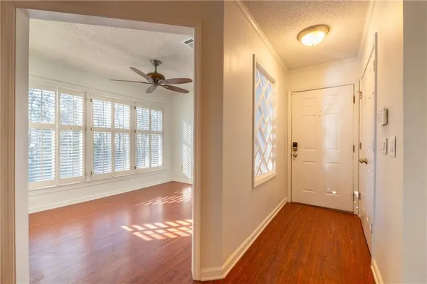 a view of an empty room with a window and wooden floor
