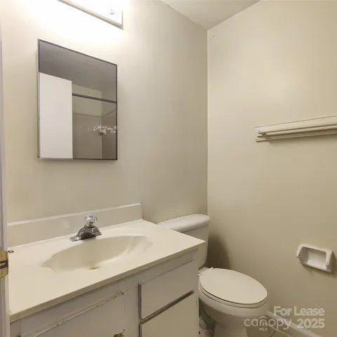 a bathroom with a sink a toilet and mirror