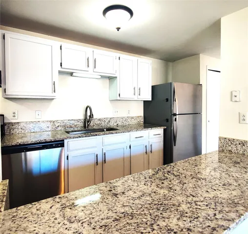 a kitchen with a refrigerator and a sink