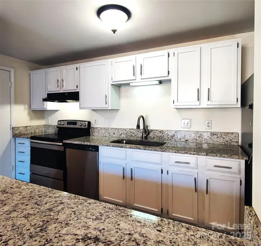 a kitchen with stainless steel appliances granite countertop a stove a sink and a refrigerator