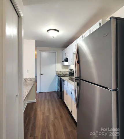 a kitchen with a refrigerator a sink and a stove top oven