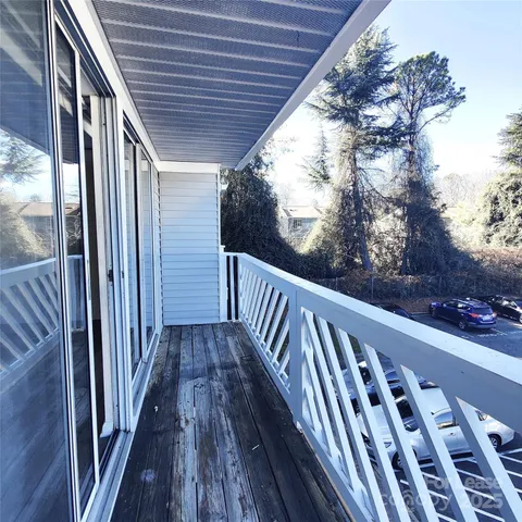 a view of balcony with wooden floor and fence