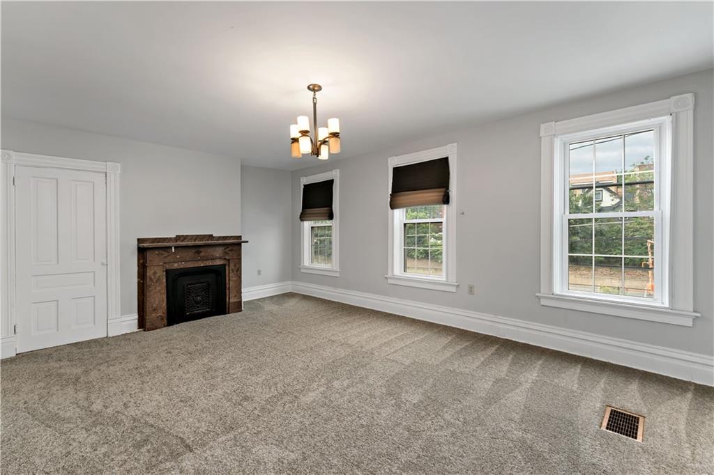 5447 Potter Street Pittsburgh, PA 15232 - Photo 12 of 36 an empty room with windows and fireplace
