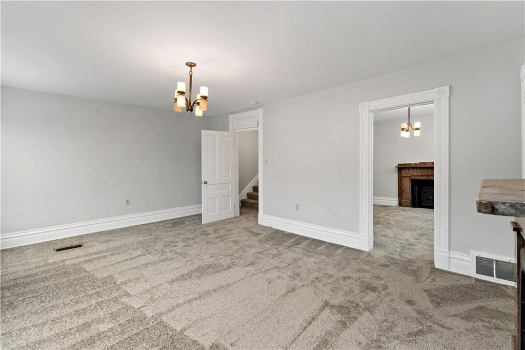 5447 Potter Street Pittsburgh, PA 15232 - Photo 16 of 36 an empty room with kitchen view and a chandelier