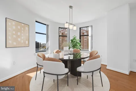 a dining room with furniture a chandelier and wooden floor