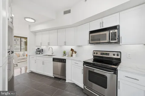 a kitchen with cabinets stainless steel appliances and sink