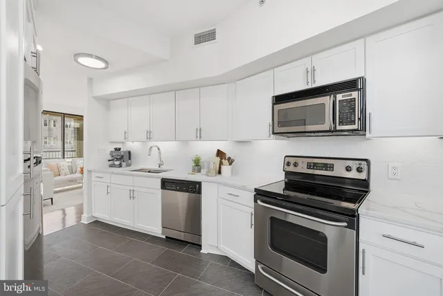 a kitchen with cabinets stainless steel appliances and sink