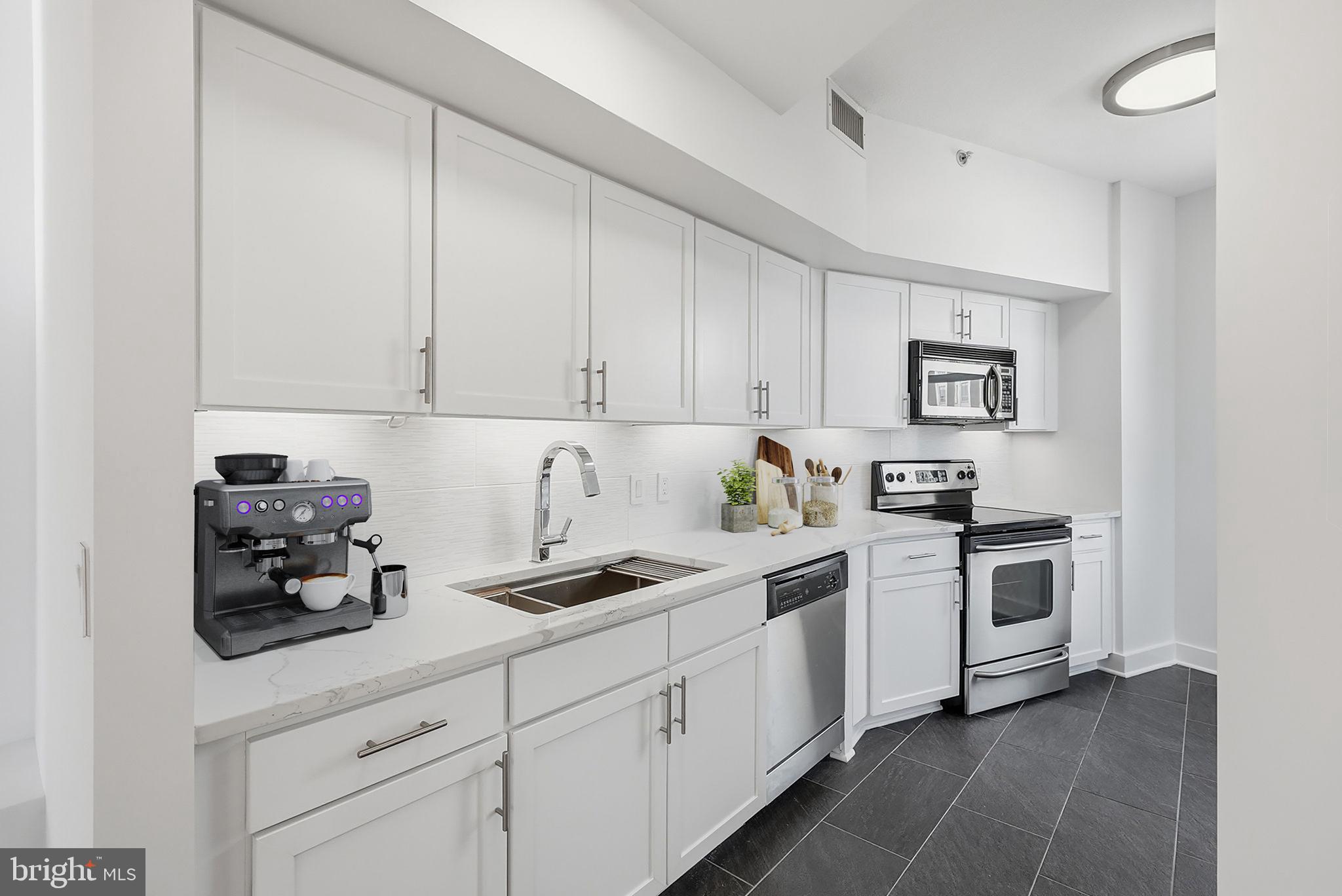 400 Massachusetts Avenue Northwest, Unit 719 Washington, DC 20001 - Photo 18 of 38 a kitchen with cabinets and white appliances