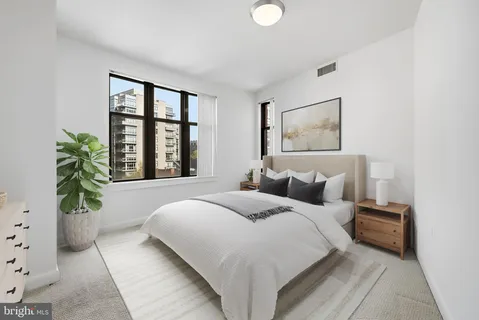 a bedroom with a large bed and a potted plant