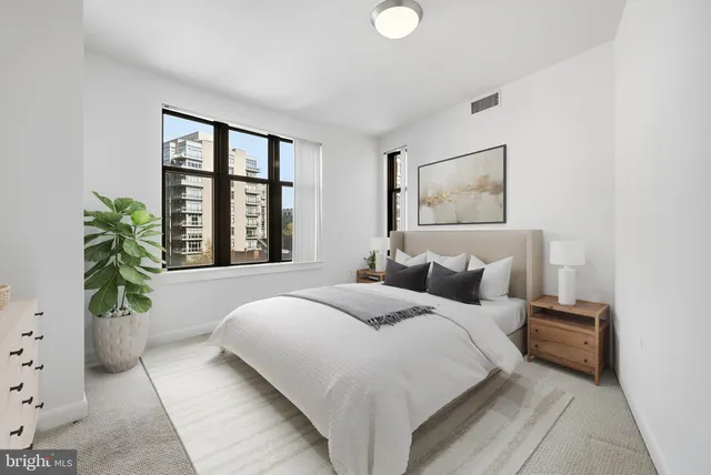a bedroom with a large bed and a potted plant